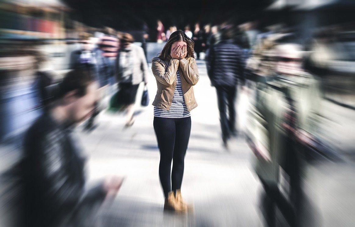 黑发女人的脸清晰的焦点模糊覆盖人群冲她周围